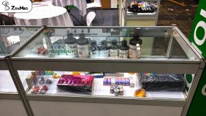 ZONMED resin bottles and stain kits on display in the booth cabinet at DenTech China 2026